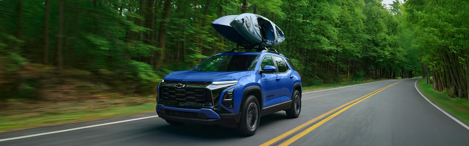 A blue Chevy Equinox from John Sauder Chevrolet, carrying two kayaks